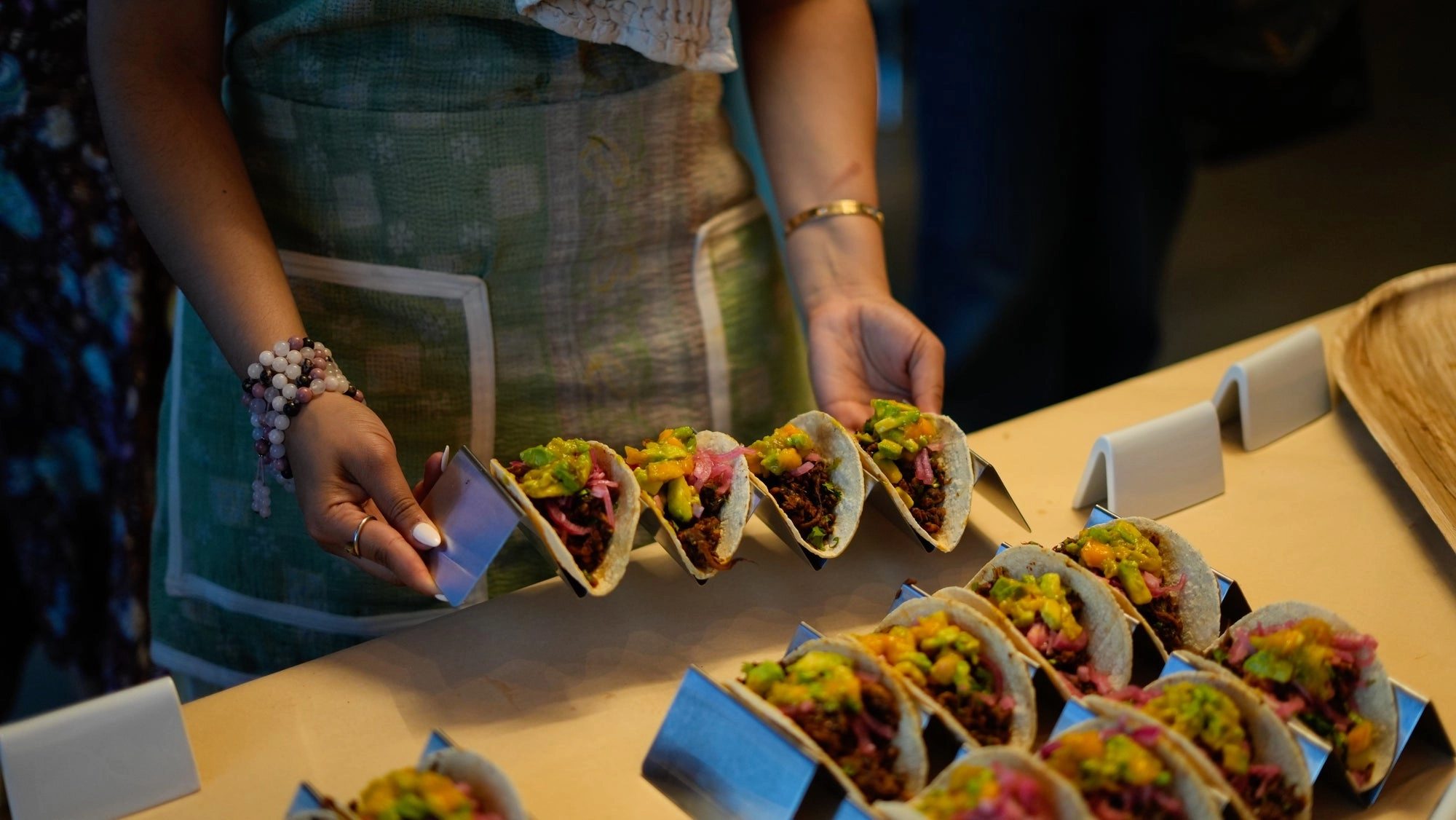 Hands setting tacos into steel holders
