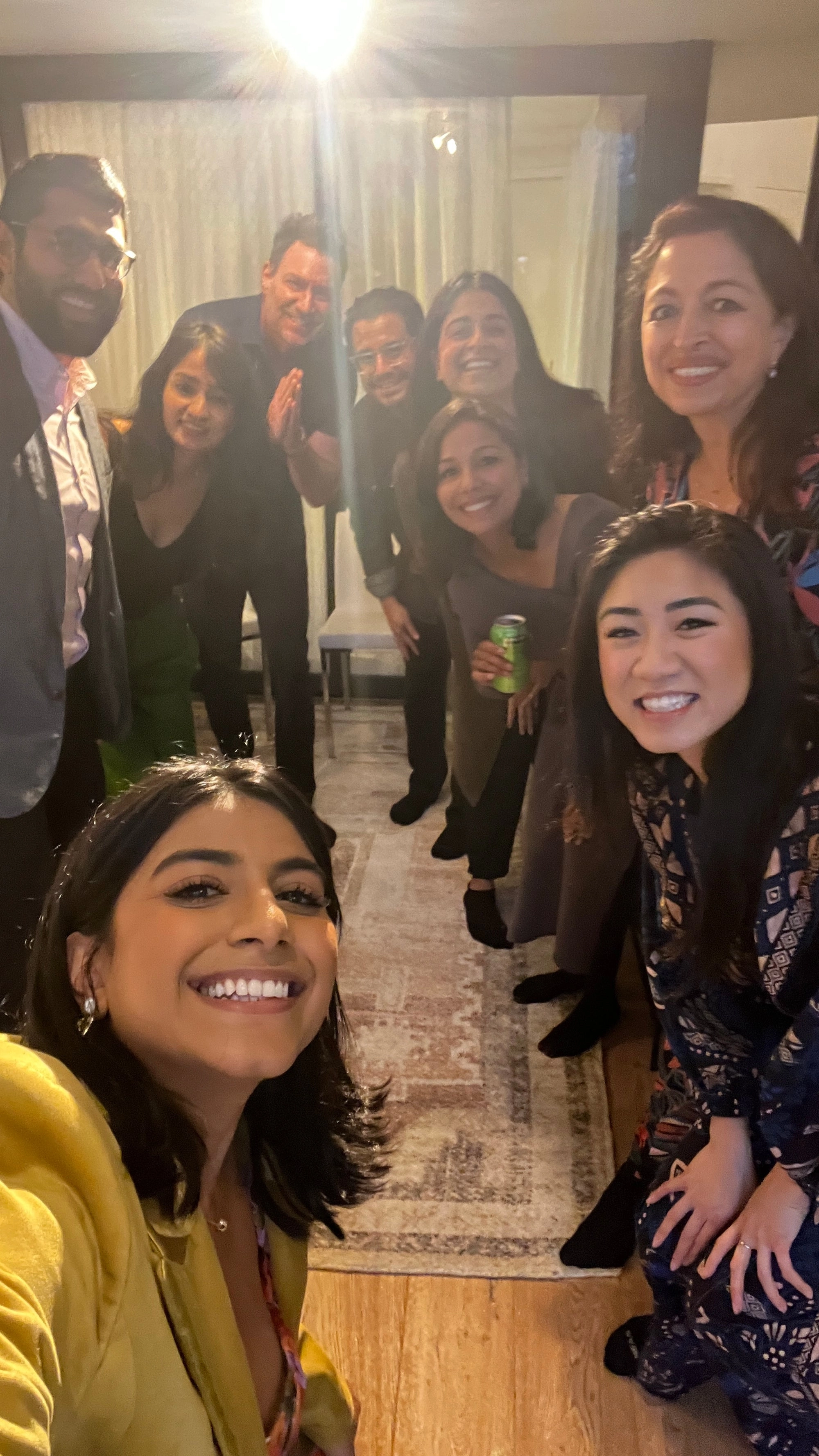 A group selfie of smiling people in a narrow room