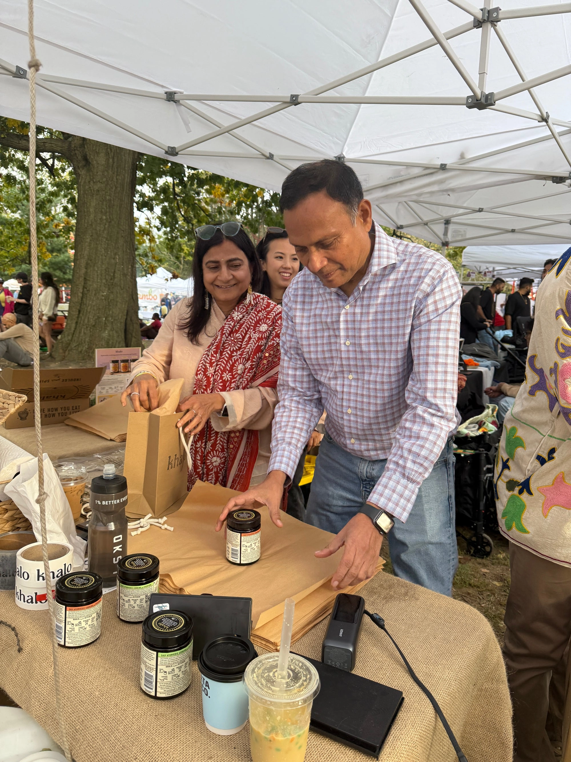 Two people chatting under a market tent